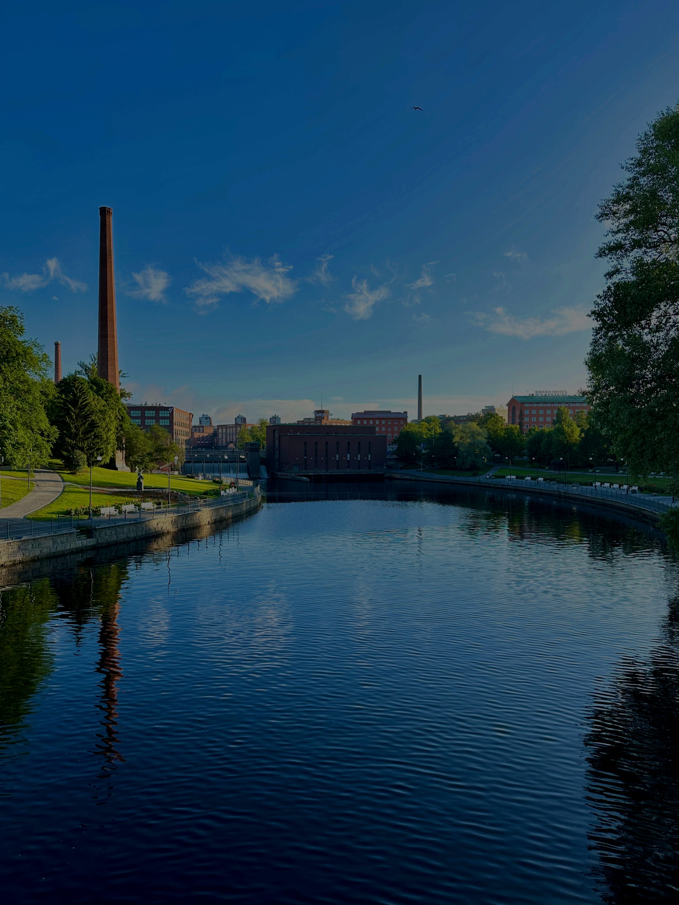 The Tammerkoski rapids bank and a factory chimney at dusk